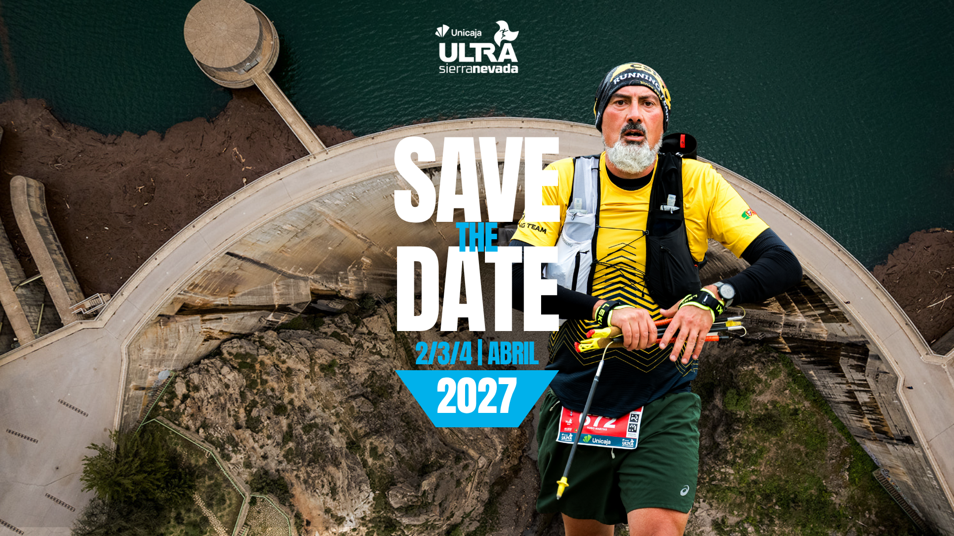 Corredor de trail running cruzando una presa en Sierra Nevada con el cartel publicitario Save the Date de la Unicaja Ultra Sierra Nevada 2027.